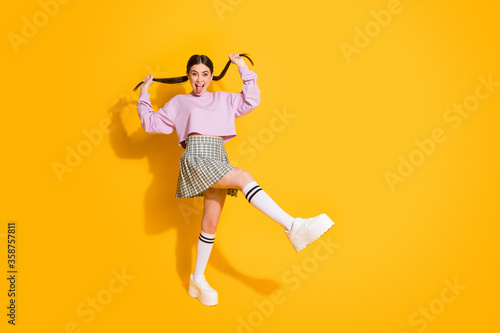 Portrait of funny childish youth hold her tails show tongue out feel foolish on spring weekend holiday wear plaid sneakers pullover isolated over bright color background