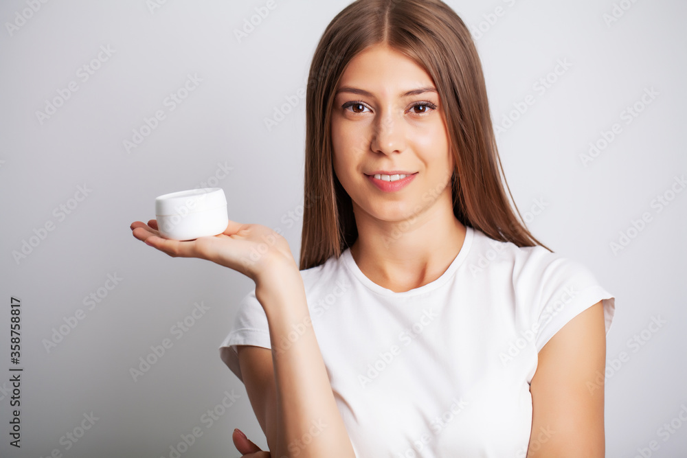 Skin care, woman with beauty face holding facial skin cream Skin care, woman with beauty face holding facial skin cream
