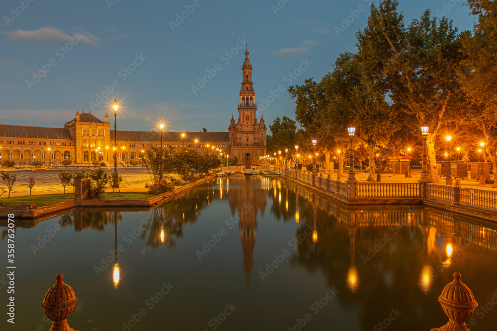 Fototapeta premium La Plaza de España de Sevilla, esta plaza es preciosa al atardecer cuando se iluminan sus farolas y se reflejan en el agua sus luces.