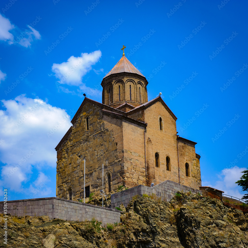 It's Metekhi Church on the elevated cliff that overlooks the Mtkvari river, one of the most popular landmarks of Tbilisi