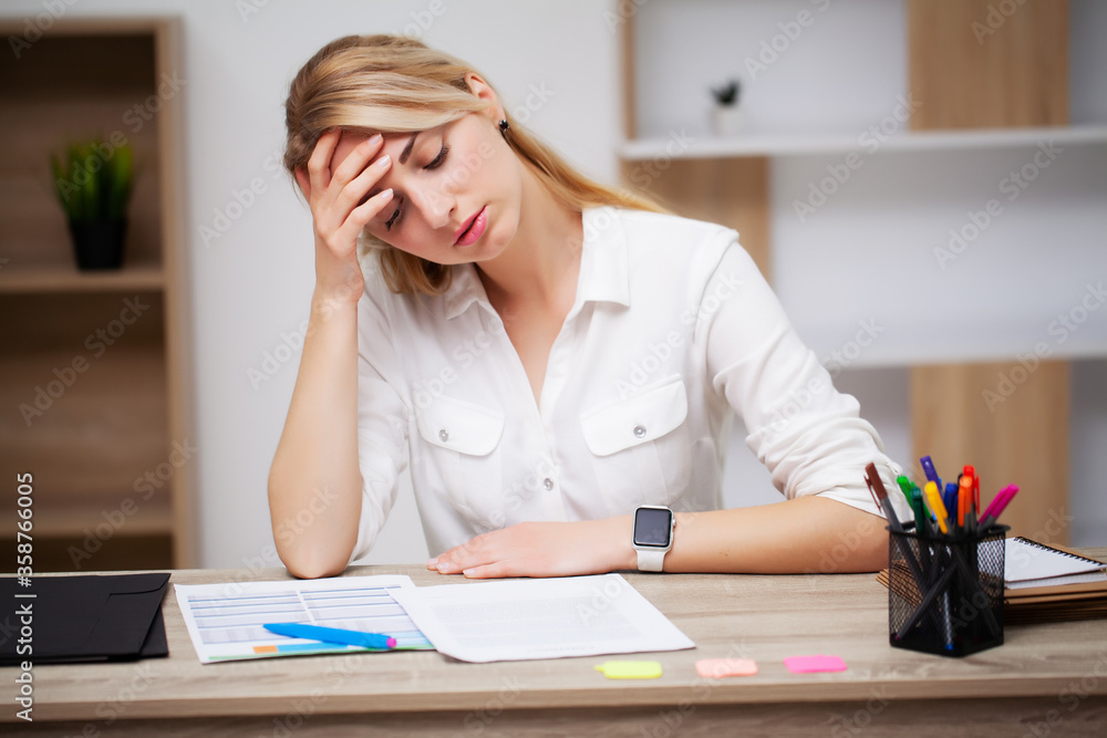 Tired business woman working with documents in the office at the desk Tired business woman working with documents in the office at the desk