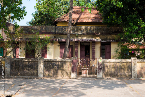 A colorful old house in the colonial city of Kochin in Kerala. Road, residential buildings and people in their daily life in the city center. Portrait of beautiful indian woman. photo