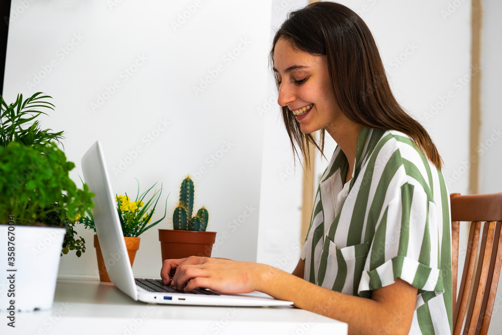 Female office worker working at home next to some plants. Concept of working with plants. Plants on the desk. Female office worker working at home next to some plants. Concept of working with plants. Plants on the desk.