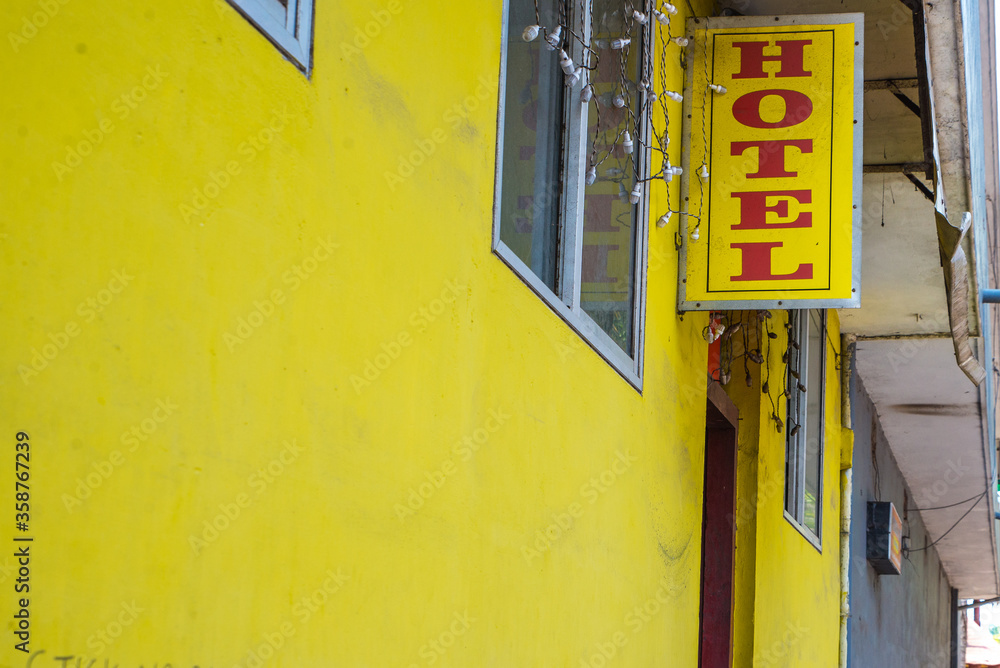 Fototapeta premium A colorful old house in the colonial city of Kochin in Kerala. Road, residential buildings and people in their daily life in the city center. Portrait of beautiful indian woman.