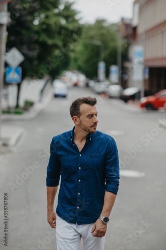 Young man goes at street near building. © Stanislav