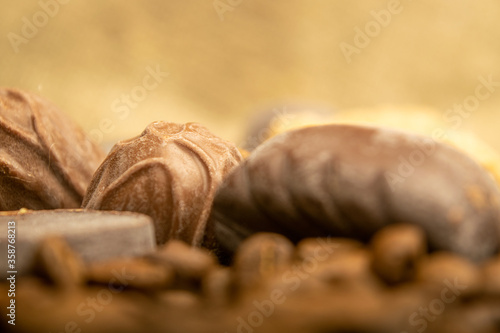Chocolate, coffee beans and chunks of brown cane sugar on a background of homespun fabric with a rough texture. Close up.