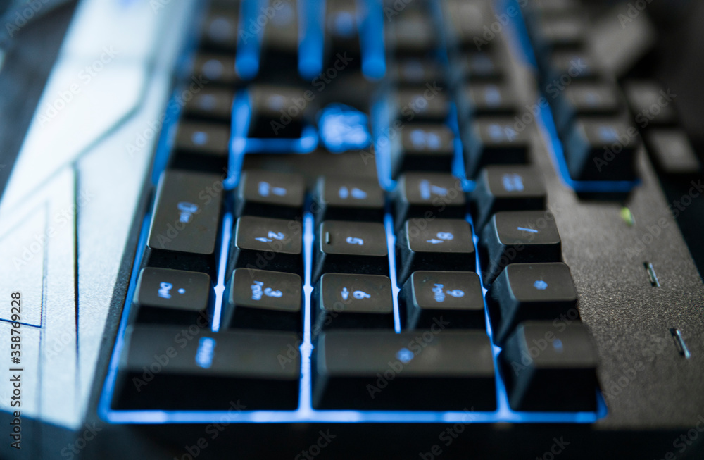 Gamer keyboard with colorful blue lights, modern gamer computer. Blue backlight, backlit on laptop or keyborad computer of gaming.