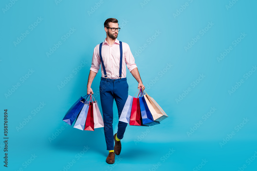 Full body photo of handsome business man worker carry many bags buy clothes vacation shopping center wear specs shirt suspenders pants boots socks isolated pastel blue color background Full body photo of handsome business man worker carry many bags buy clothes vacation shopping center wear specs shirt suspenders pants boots socks isolated pastel blue color background