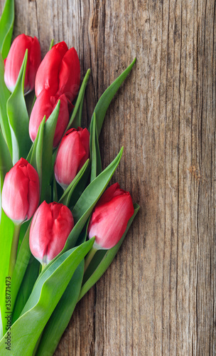 Red tulips bouquet isolated on wooden background