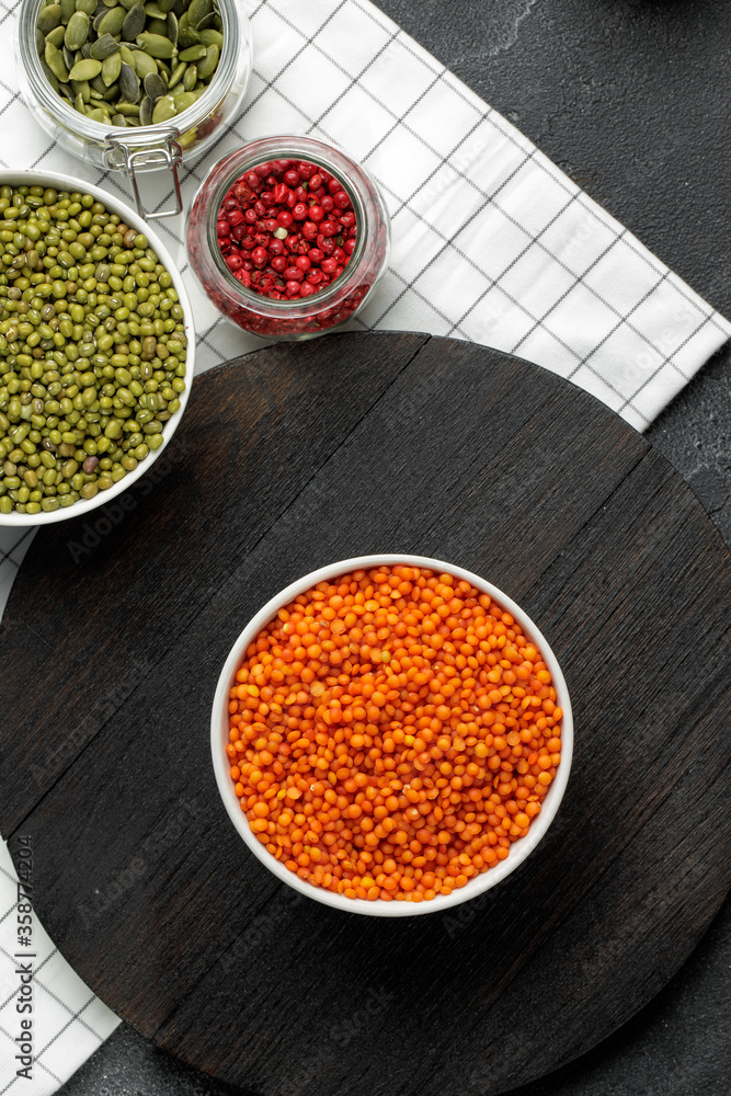 White ceramic bowl of red lentils on wooden table White ceramic bowl of red lentils on wooden table