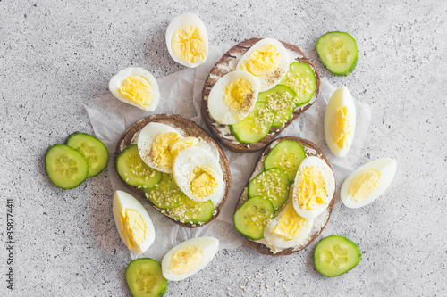 Sandwiches with egg, cucumber, sesame seeds and spices. Tasty breakfast. Sandwiches on the table