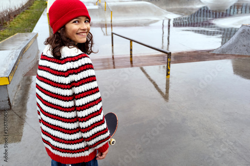 Smiling Girl with Skateboard on training ground