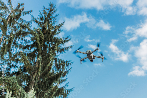 Drone flying in the air with blue sky in the background. Outdoor photo