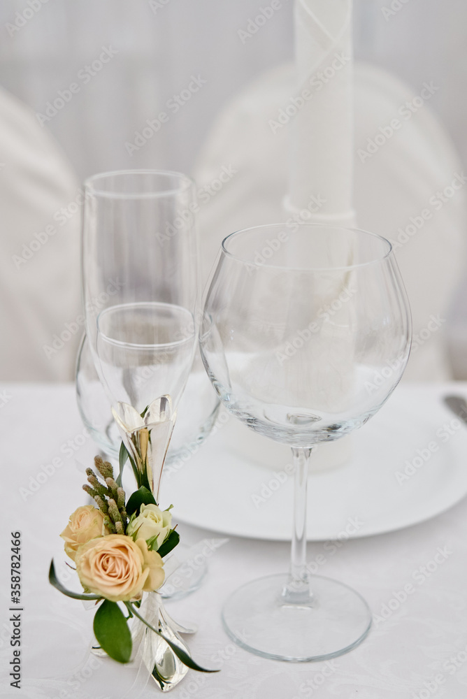 Table setting with sparkling wineglasses, plate with white napkin and cutlery on table, copy space. Place set at wedding reception. Table served for wedding banquet in restaurant Table setting with sparkling wineglasses, plate with white napkin and cutlery on table, copy space. Place set at wedding reception. Table served for wedding banquet in restaurant