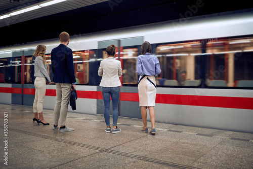 Obraz na plátně group of young caucasian business people at subway station waiting for a train