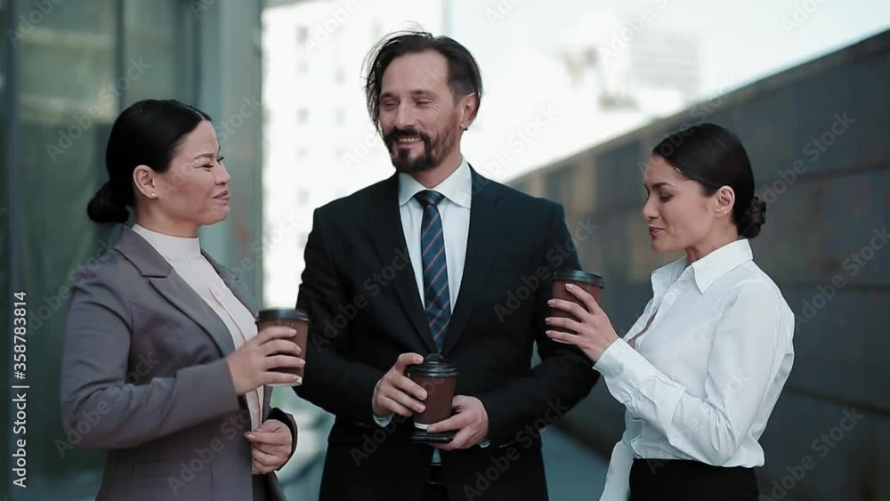 Freelancers colleagues drinking coffee in business clothes standing outdoors near office building. Business people having a coffee break. Business concept. Cold tone footage. Prores 422. Freelancers colleagues drinking coffee in business clothes standing outdoors near office building. Business people having a coffee break. Business concept. Cold tone footage. Prores 422.