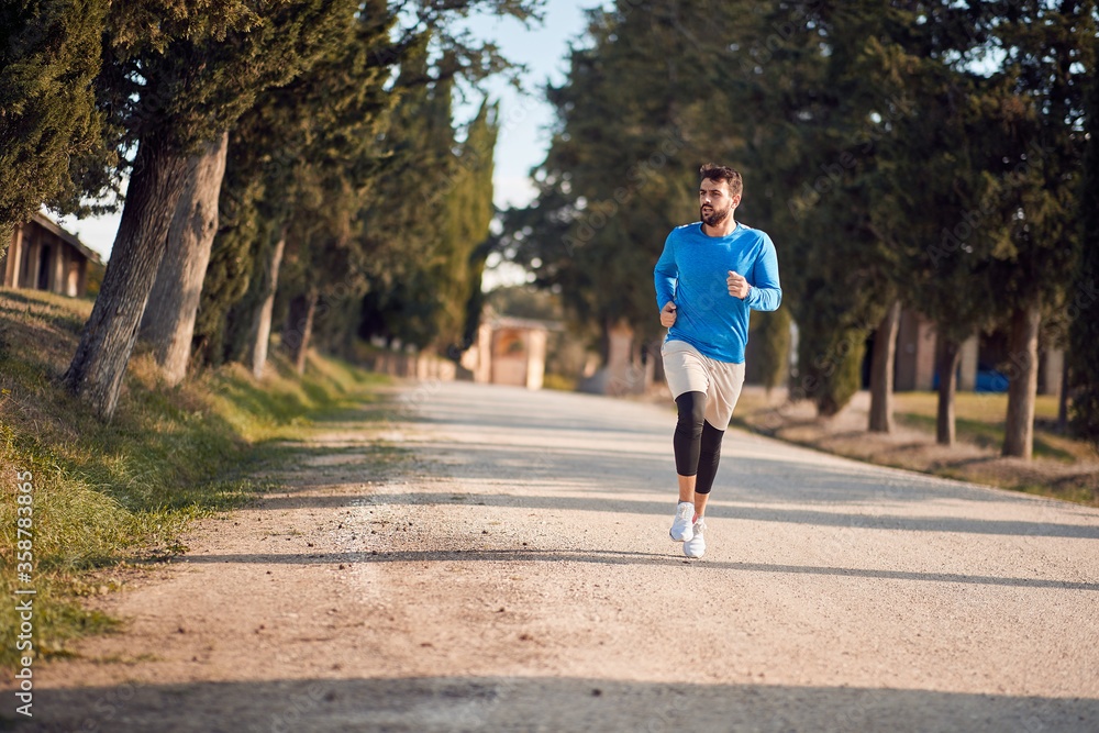 young caucasian adult man jogging in beautiful region of italy young caucasian adult man jogging in beautiful region of italy