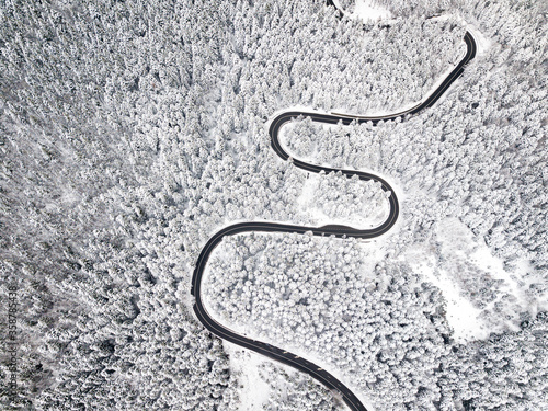 Beautiful aerial view of a curvy winding road with serpentine and white snow trees © Rafaila Gheorghita