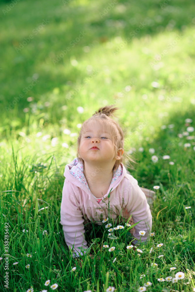 Little cute girl in everyday creeps on green grass. Little cute girl in everyday creeps on green grass.