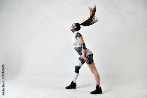 beautiful brunette girl in a robot suit posing on a white background
