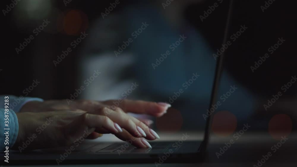 Female hands is typing on a laptop at night Female hands is typing on a laptop at night