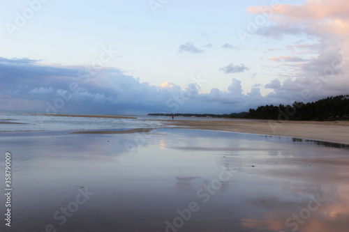 Guarajuba beach  Bahia  Brazil. Dawn with a cloudy sky over the calm waters of the ocean. In the background vegetation.