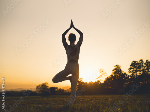 Fototapeta Naklejka Na Ścianę i Meble -  Woman yoga. Young female doing yoga on nature outdoors.
