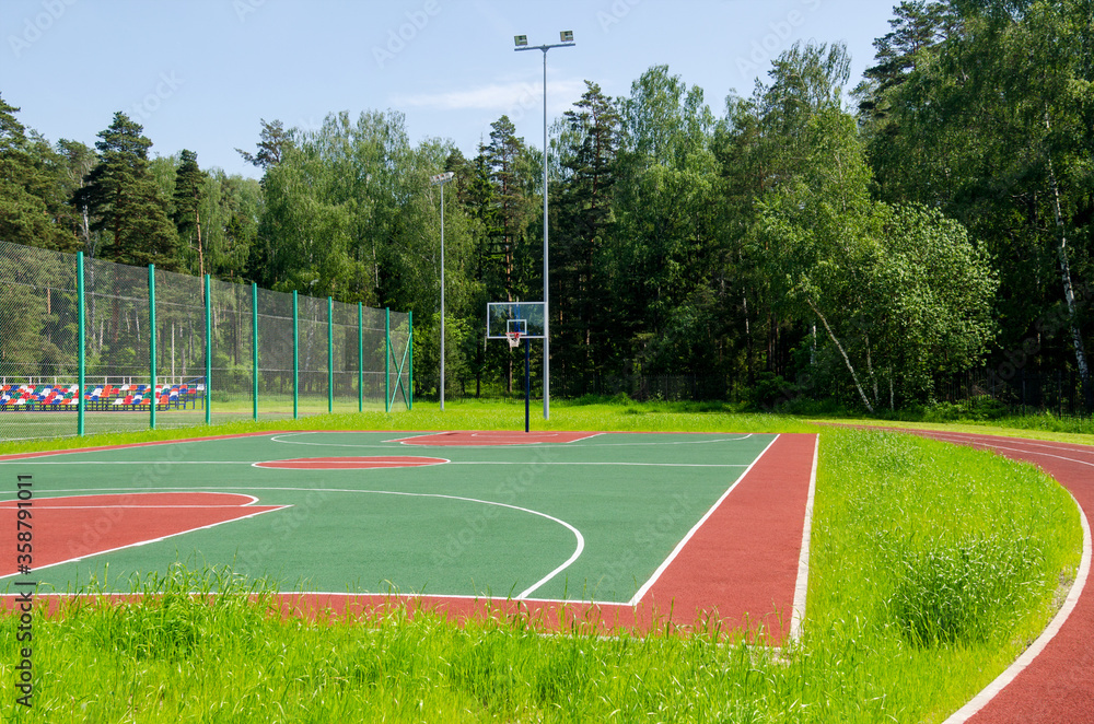Fototapeta premium Empty street basketball court in the park on the sunny summer day.