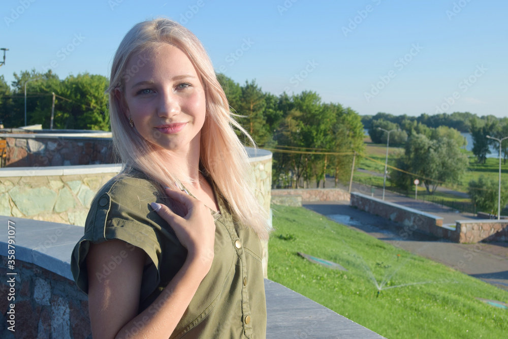 portrait of young blond woman in park 