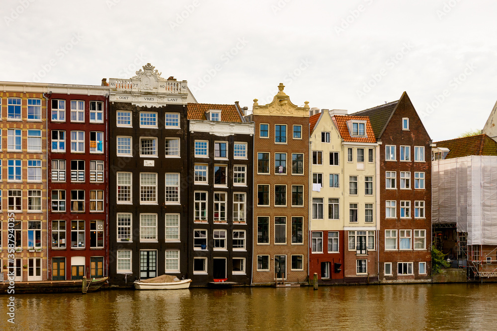 Buildings in front if the Damrak street, Amsterdam, the capital of the Kingdom of Netherlands