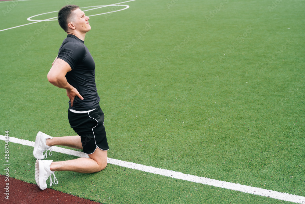 The athlete is holding on to his back. The concept of pain in a sn down during a workout.