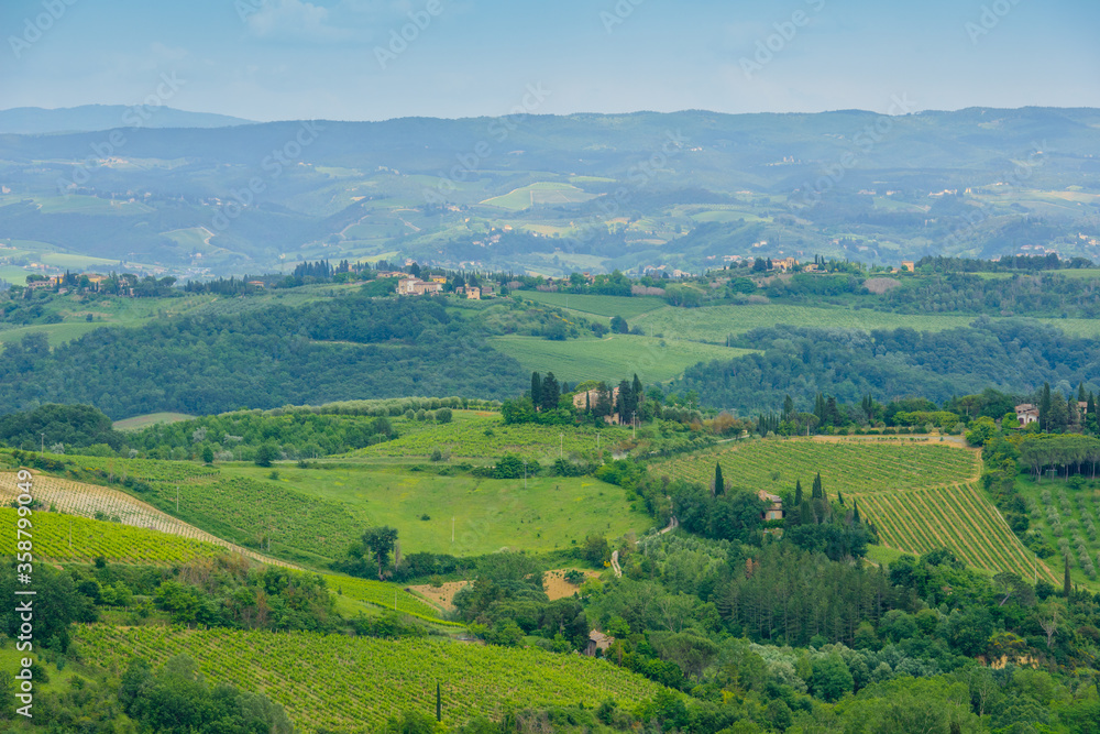 Tuscan countryside with rolling hills, vineyards and farmhouses seen from a medieval hill town of San Gimignano, Province of Siena, Tuscany, Italy. Tuscan countryside with rolling hills, vineyards and farmhouses seen from a medieval hill town of San Gimignano, Province of Siena, Tuscany, Italy.