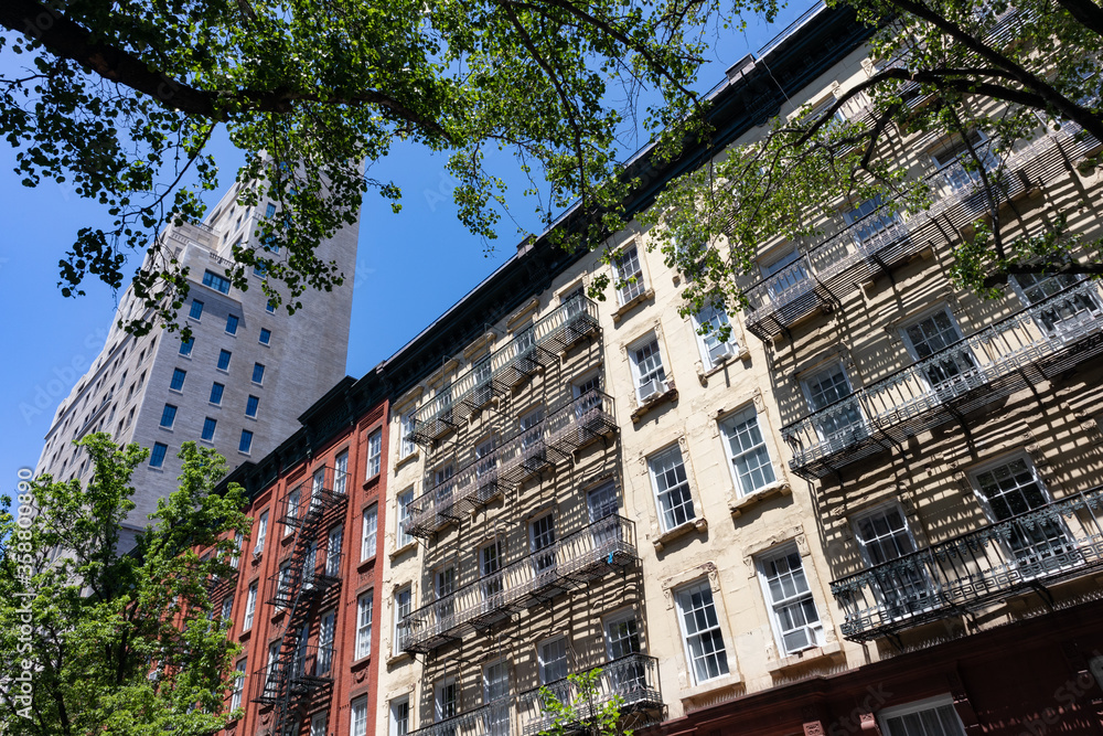 Row of Colorful Old Buildings with Fire Escapes on the Upper East Side of New York City with Green Trees