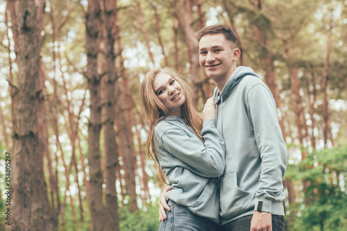 couple in identical sweatshirts in the forest, portrait of a couple in the forest