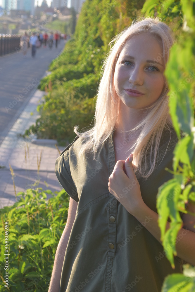 Portrait of blonde teenager in a park with hand in hair Portrait of blonde teenager in a park with hand in hair