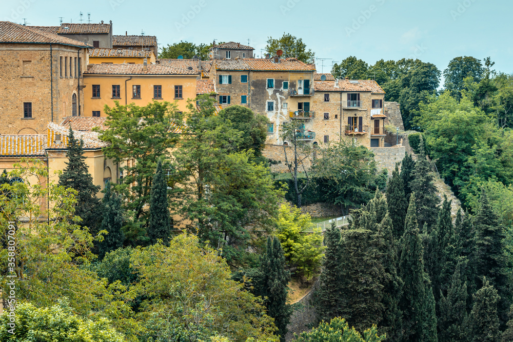 Residential houses of the old town built on a steep slope in a popular hilltop town of Volterra, Tuscany, Italy, seen from Piazza XX Settembre.
