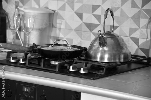 Stainless steel stove, kettle and pan in a modern kitchen. Close-up