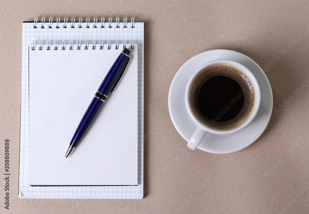 black espresso in a cup and notebooks and a pen on light pastel tones background black espresso in a cup and notebooks and a pen on light pastel tones background