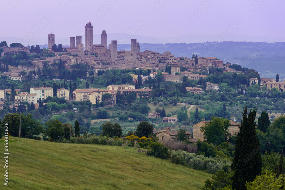 Skyline of the hill town of San Gimignano with its 14 tall towers, known as Medieval Manhattan, set among rolling hills of Tuscan countryside, Italy.