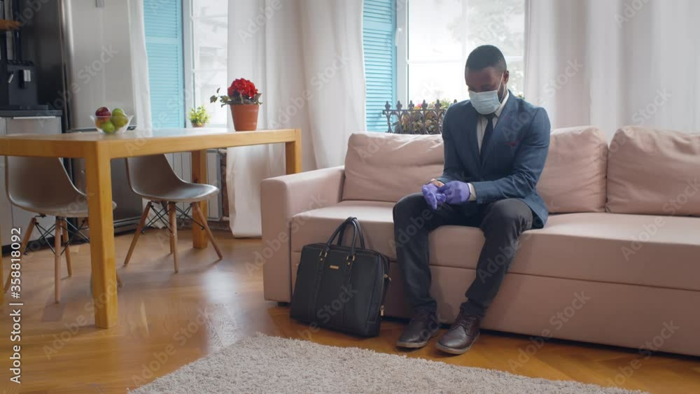 African entrepreneur in gloves and mask going out for work African entrepreneur in gloves and mask going out for work