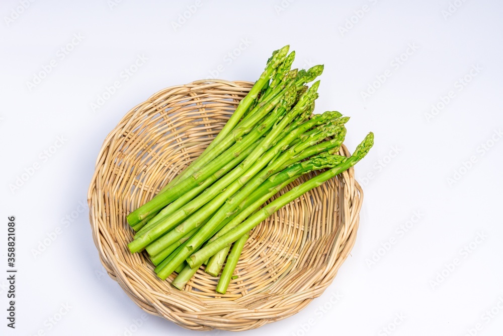 Asparagus on the wooden basket on the white background. Asparagus on the wooden basket on the white background.