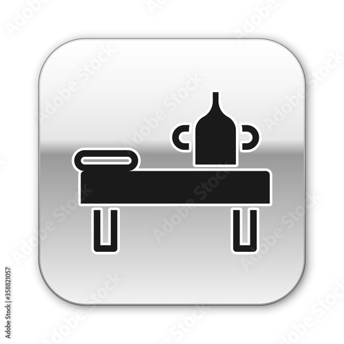 Black Massage table with oil icon isolated on white background. Silver square button. Vector
