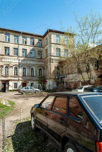 The courtyard of the old building with standing cars and a path to the entrance © Денис Кичев