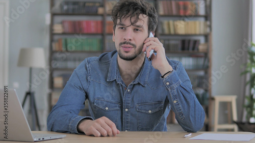 Phone Talk, Young Man Attending Call at Work photo