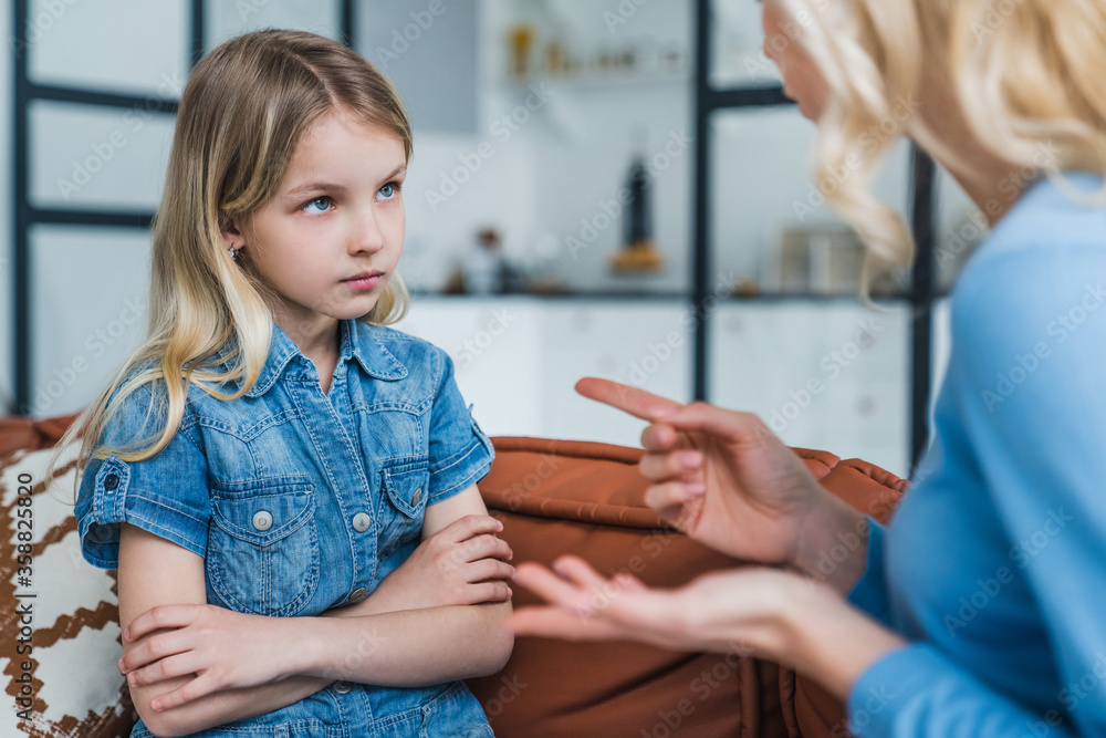 Ταπετσαρία Little girl looking sad while her mother scolding her sitting on couch at home