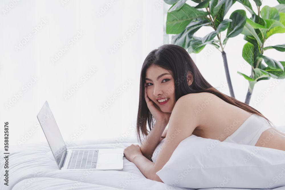 Asian beautiful girl wearing casual clothes and play or work with computer. Happily in the house. Concept Work for home and relax time. Asian beautiful girl wearing casual clothes and play or work with computer. Happily in the house. Concept Work for home and relax time.