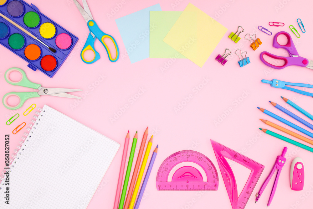 Back to school concept on pink background. School supplies and open notebook on pastel pink background Back to school concept on pink background. School supplies and open notebook on pastel pink background