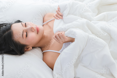 Beautiful woman sleeping and close eye in the white bed