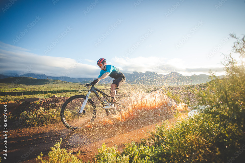 Fototapeta premium Wide angle view of a mountain biker speeding downhill on a mountain bike track.