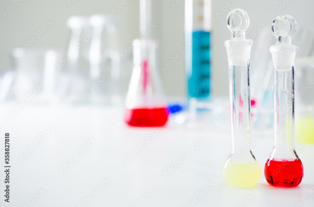 2 sciscience vials with corks placed next to each other, with red and light green water inside